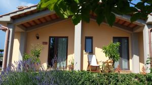 a house with two chairs in front of it at Agriturismo Podere La Cascata in Massa Marittima
