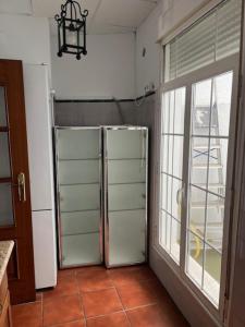 a kitchen with a refrigerator and a large window at Casa Puente ROMANO cerca de Sevilla in Alcalá de Guadaira