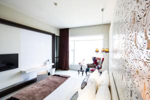 a living room with a couch and a large window at Mode Sathorn Hotel - SHA Extra Plus in Bangkok