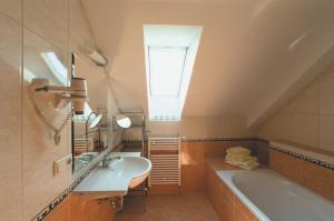 bagno con lavandino, vasca e finestra di Maltschacher Seewirt a Feldkirchen in Kärnten
