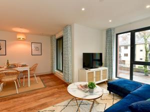 un salon avec un canapé bleu et une table dans l'établissement Pass the Keys Beautiful 3 Bed Town House, à Cardiff