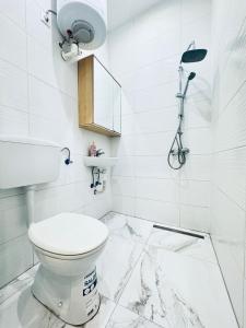 a white bathroom with a toilet and a shower at Convenient Stay 4BR Shared Apt for 11P, 10 Min to Atzgersdorf in Vienna