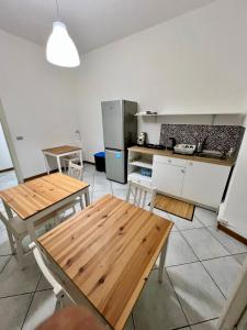 a kitchen with two wooden tables and a refrigerator at La Dolce Vita in Catania