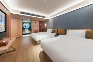 Giường trong phòng chung tại Orange Hotel Guilin Yangshuo West Street Branch