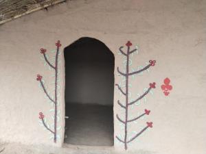 a tunnel with flowers painted on the side of a wall at Mera Gaon Albela in Ambāla Cantonment