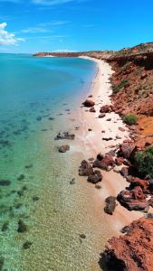a view of a beach with rocks and water at Wildsights Beach Units in Denham
