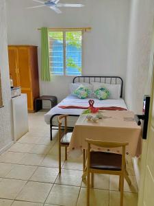 a bedroom with a bed and a table in it at Room With A View & Apartment Style in Port Vila