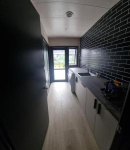 a kitchen with a sink and a brick wall at Lake Opuha House in Ashwick Flat +11 photos