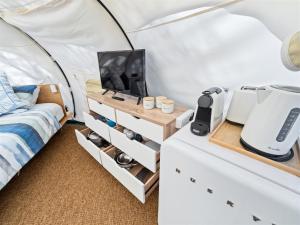 a bedroom with a bed and a tv in a tent at Mandalay Holiday Resort and Tourist Park in Busselton