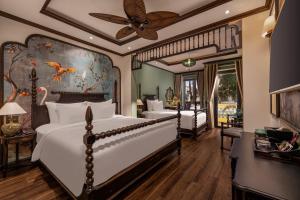 a bedroom with two beds and a ceiling fan at The An Bang Vanessa - Indochine Boutique Hotel in Hoi An