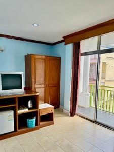 Il comprend un salon doté d'une télévision et d'une fenêtre. dans l'établissement Innarm House Patong, à Patong Beach