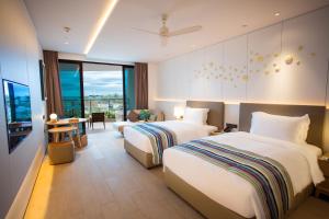 a hotel room with two beds and a living room at Sanya Conifer Resort in Sanya +93 photos