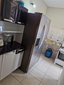 a kitchen with a refrigerator and a counter top at Quadra 6 Paiaguás Parque das Águas Cuiabá in Cuiabá