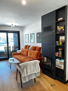 a living room with a couch and a table at Apartment Aurora in Bjelašnica