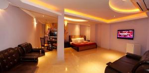 ein Wohnzimmer mit einem Bett und einer Couch in der Unterkunft Ambassador Inn in Islamabad