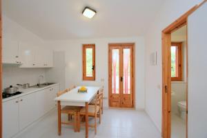 Una cocina con una mesa y sillas y un fregadero. en Residence Villa Agrimare, en Vieste