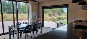 a kitchen with a table and chairs and a large window at Lake Opuha House in Ashwick Flat