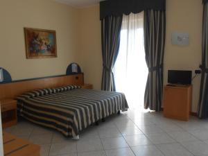 ein Schlafzimmer mit einem Bett und einem großen Fenster in der Unterkunft Albergo Villa Eva in Costermano sul Garda