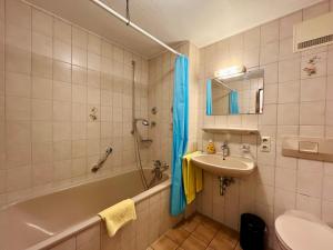 a bathroom with a tub and a sink and a shower at Haus Baur, Fewo Dorfstadl 37 oder Heustadl 38 in Oberstdorf