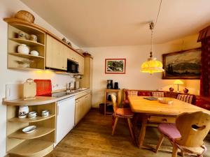 a kitchen with a wooden table and a dining room at Haus Baur, Fewo Dorfstadl 37 oder Heustadl 38 in Oberstdorf