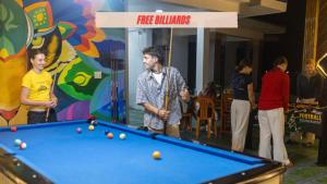a group of people standing around a pool table at Green Riverside Cosy Home in Phong Nha