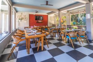 a restaurant with wooden tables and chairs and a checkered floor at Humming Bird By Aaryam in Ukhimath