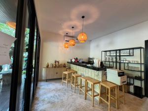 a kitchen with a counter and stools in a room at 7Senses Resort in Ko Chang