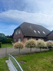 a house with flowering trees in front of it at Ferienhaus Küstenbär Burhave in Burhave