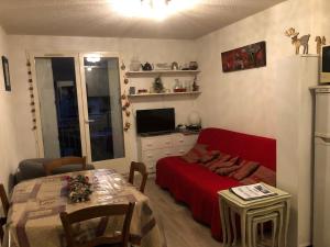 a living room with a red couch and a table at Les Jardins du Casino T2 bis- 4 personnes-Tarif cures 700 euros in Luchon
