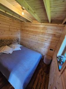 Un dormitorio con una cama en una cabaña de madera. en Sodyba pas Martyna, en Triušiai 64 fotos más