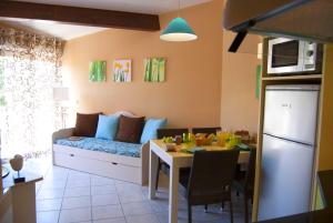 una sala de estar con un sofá y una mesa en Lagrange Grand Bleu Vacances – Résidence Les Jardins de Neptune, en Saint-Cyprien