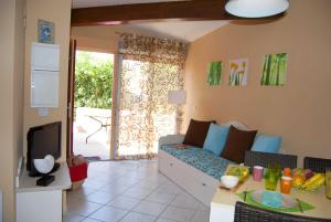 Una sala de estar con un sofá y un televisor. en Lagrange Grand Bleu Vacances – Résidence Les Jardins de Neptune, en Saint-Cyprien