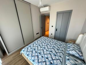a bedroom with a bed with a blue comforter at Exclusive Residence Famagusta in Famagusta