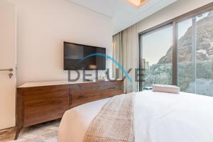 a bedroom with a bed and a tv and a window at Limited Offer 4BR plus Maid's Villa Close to Beach by Deluxe Holiday Homes in Fujairah