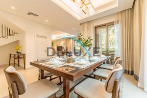 a dining room with a large wooden table and chairs at Limited Offer 4BR plus Maid's Villa Close to Beach by Deluxe Holiday Homes in Fujairah