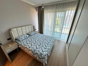 a bedroom with a bed and a large window at Exclusive Residence Famagusta in Famagusta