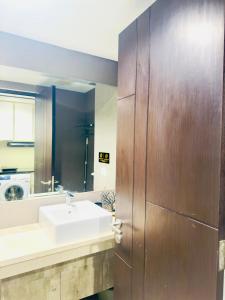 Un baño con lavabo y puerta de madera. en ALPATRA Studio Amarta Patraland, en Kejayan