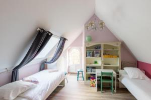 a attic bedroom with two beds and a table at La Ruchaude Enchantée - Grand jardin et sauna in Chevillon