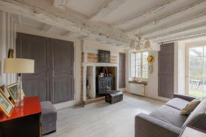 a living room with a couch and a fireplace at La Ruchaude Enchantée - Grand jardin et sauna in Chevillon