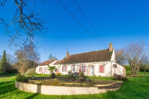a white house with red shutters on a green yard at La Ruchaude Enchantée - Grand jardin et sauna in Chevillon