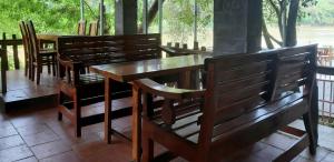 une rangée de bancs et de tables en bois dans un restaurant dans l'établissement Quang Minh River View Hotel, à Cat Tien