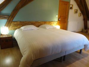 a bedroom with a large white bed with two lamps at Gites de Gondières in Saint-Éloi