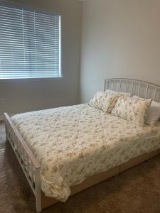 a bed in a white bedroom with a window at Cozy Retreat for Work or Relaxation in Cedar Park