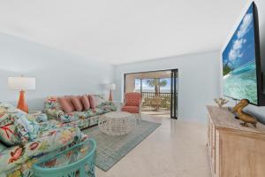 a living room with a couch and a tv at Sanddollar #A202 in Ybel