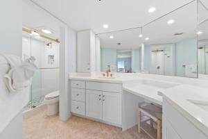 a white bathroom with a sink and a toilet at Sanddollar #A202 in Ybel +43 photos