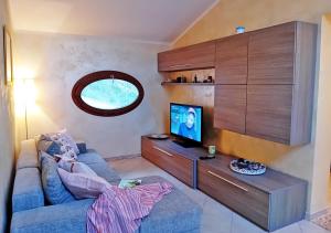 a living room with a blue couch and a tv at Le Maree La Mansarda in Rio Marina