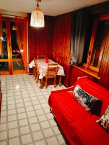 een woonkamer met een rode bank en een tafel bij Mirtilli in Prato Nevoso