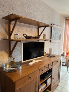 een houten entertainmentcentrum met een flatscreen-tv bij Mirtilli in Prato Nevoso