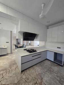 a kitchen with white cabinets and a stove top oven at Satish Villa in Hyderabad