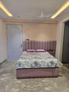 a bedroom with a large bed with a purple headboard at Satish Villa in Hyderabad